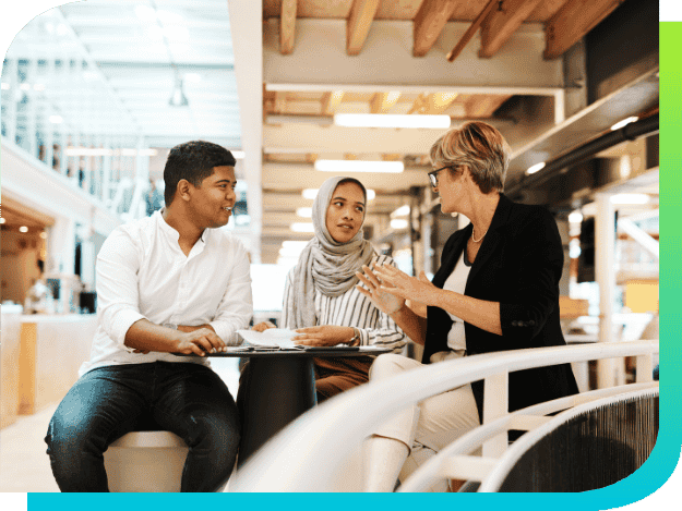 a group of coworkers talking at a table in a modern office